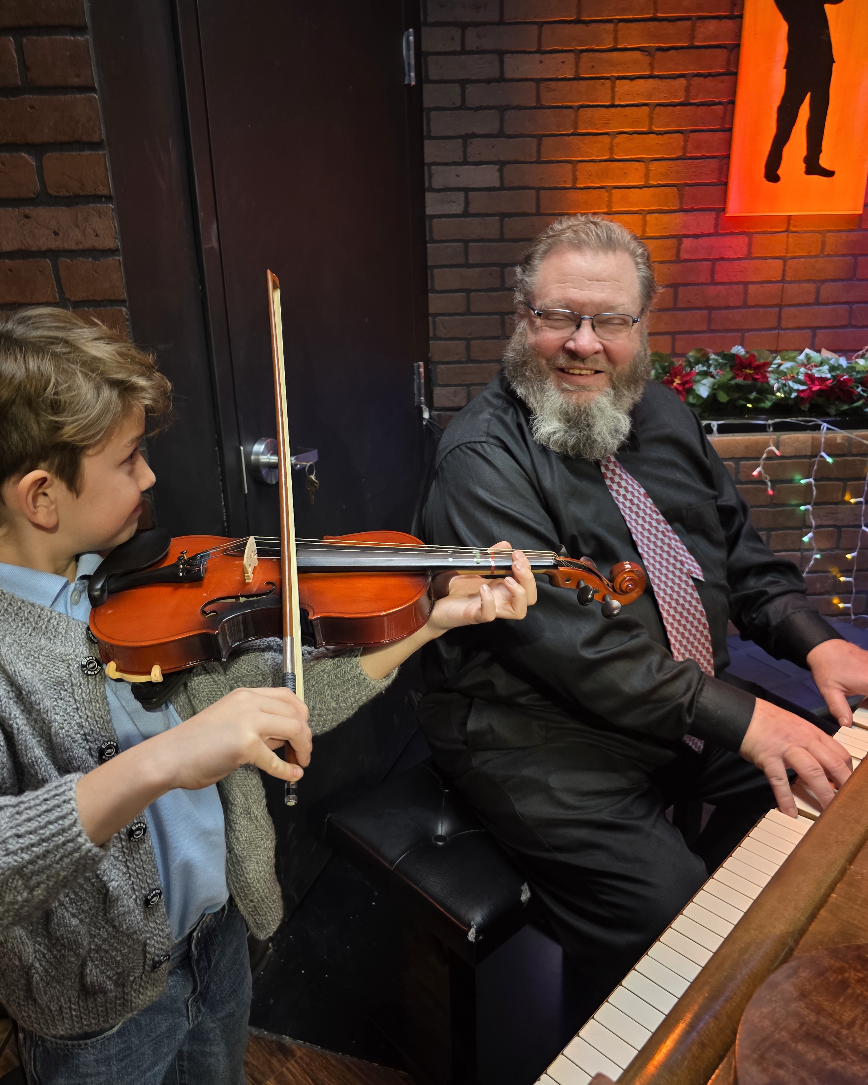 Teacher and student playing piano and violin together at Keys of Joy! Studio