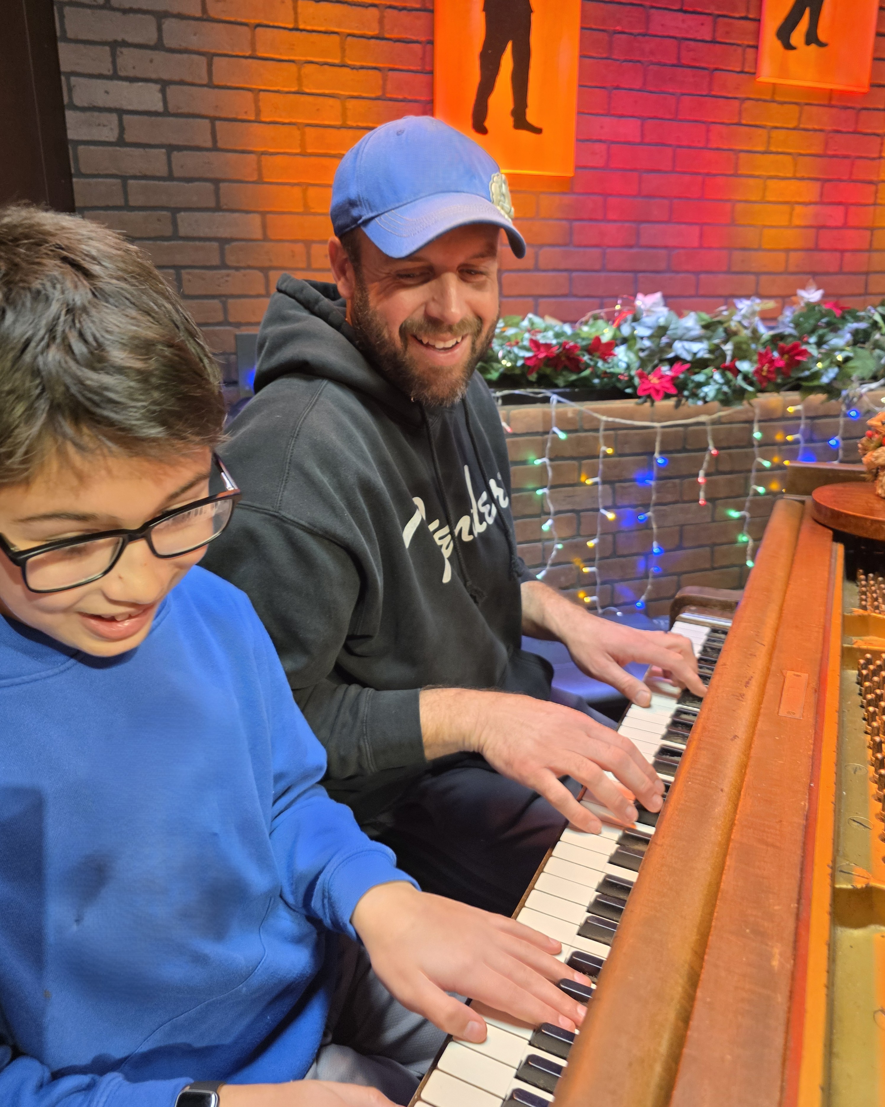 A parent and child playing a piano duet together at Keys of Joy! Studio in Lawrence, KS