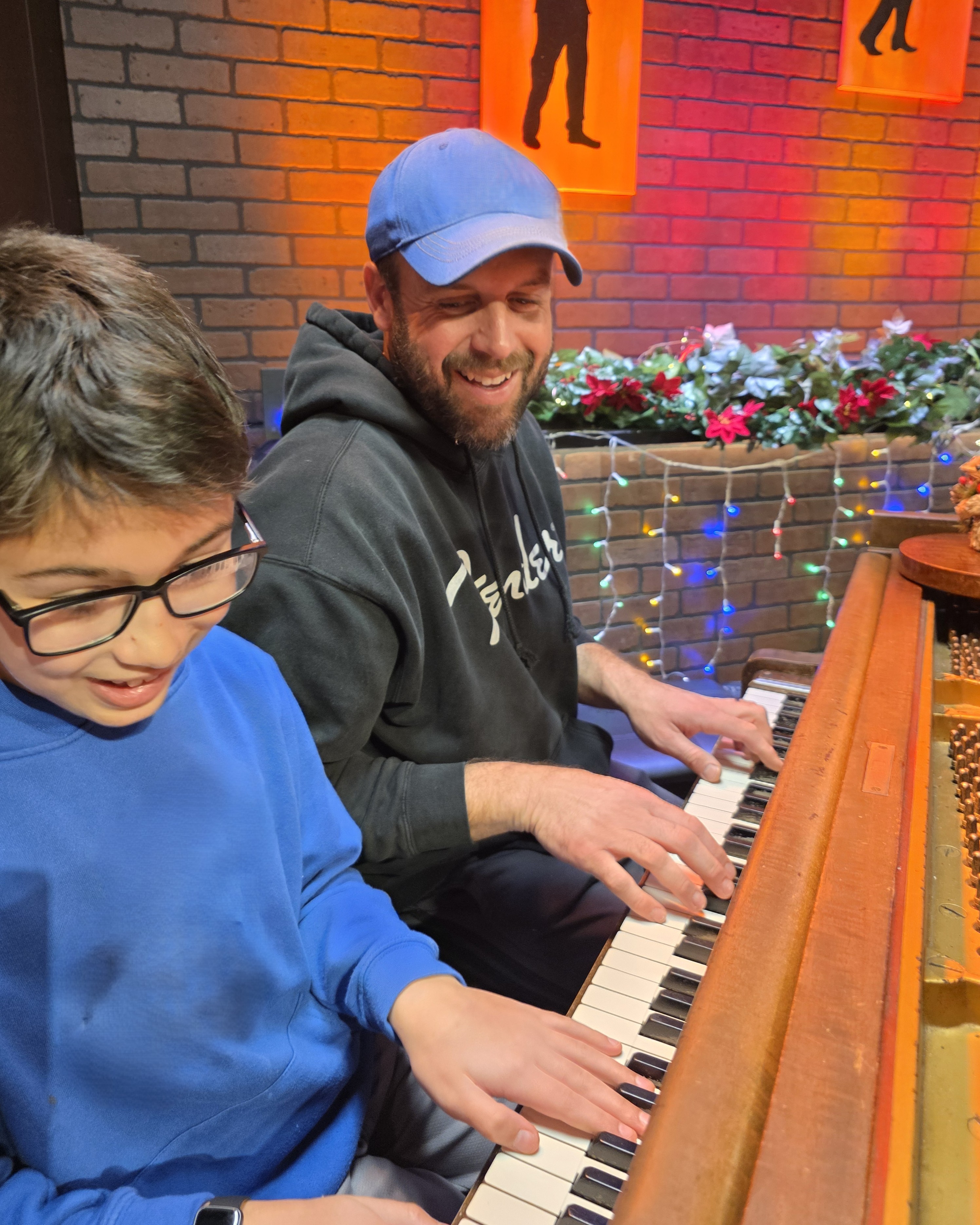 A parent and child playing a piano duet together at Keys of Joy! Studio in Lawrence, KS